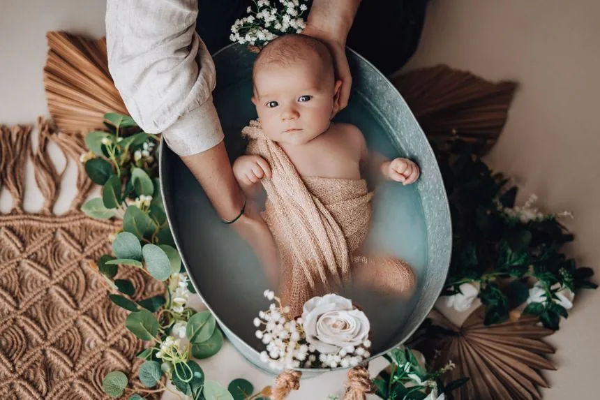 Bébé dans la bassine du bain enveloppé, décor fleuri